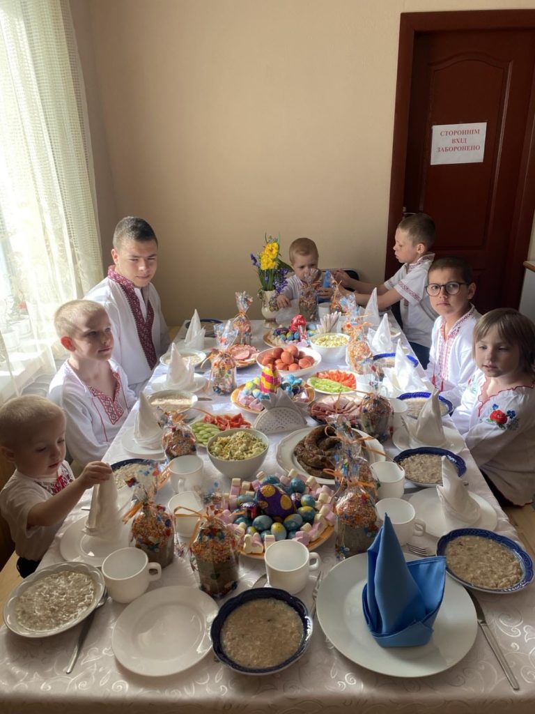Children at Larisa's orphanage sat around a table enjoying an Easter meal