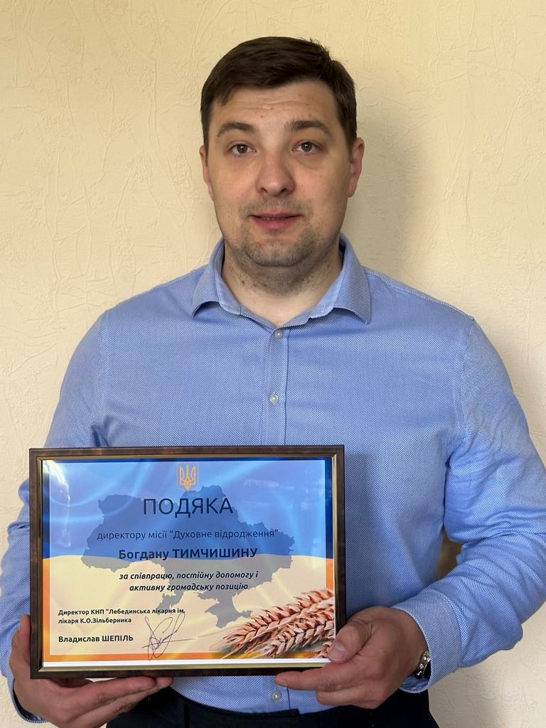 Bohdan holding his framed certificate