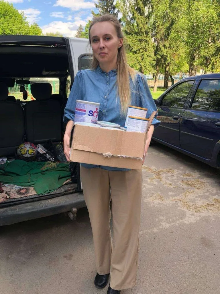 One of ladies from the team unloading baby food from a car