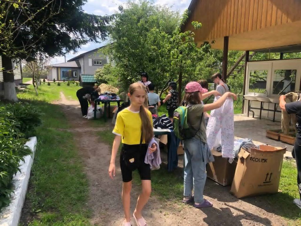 Women and children looking through boxes of clothes outside the Centre