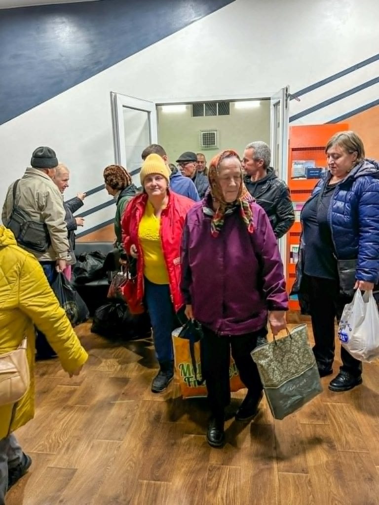 Ladies exiting the Centre carrying bags of collected humanitarian aid.