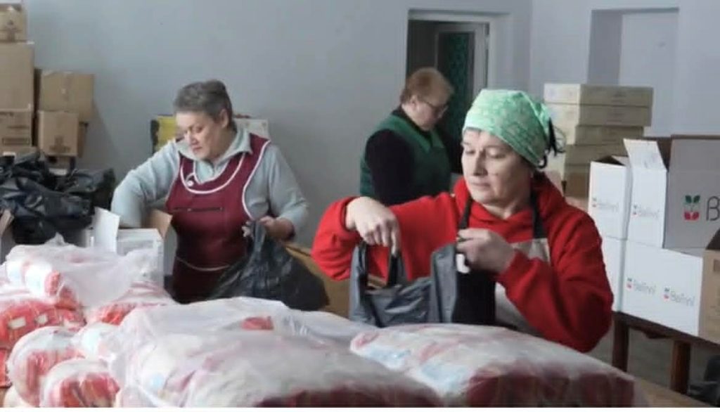 Volunteers packing food items into bags in the Centre.