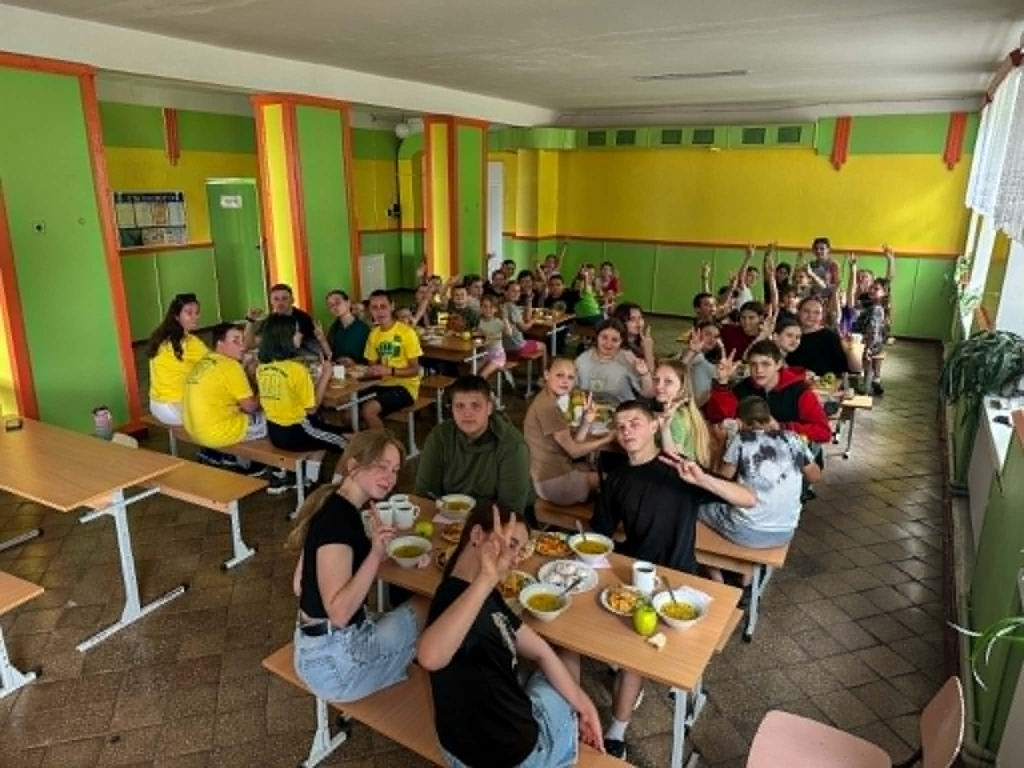 Children and youth leaders enjoy lunch together during a summer camp programme in Grintsevo.