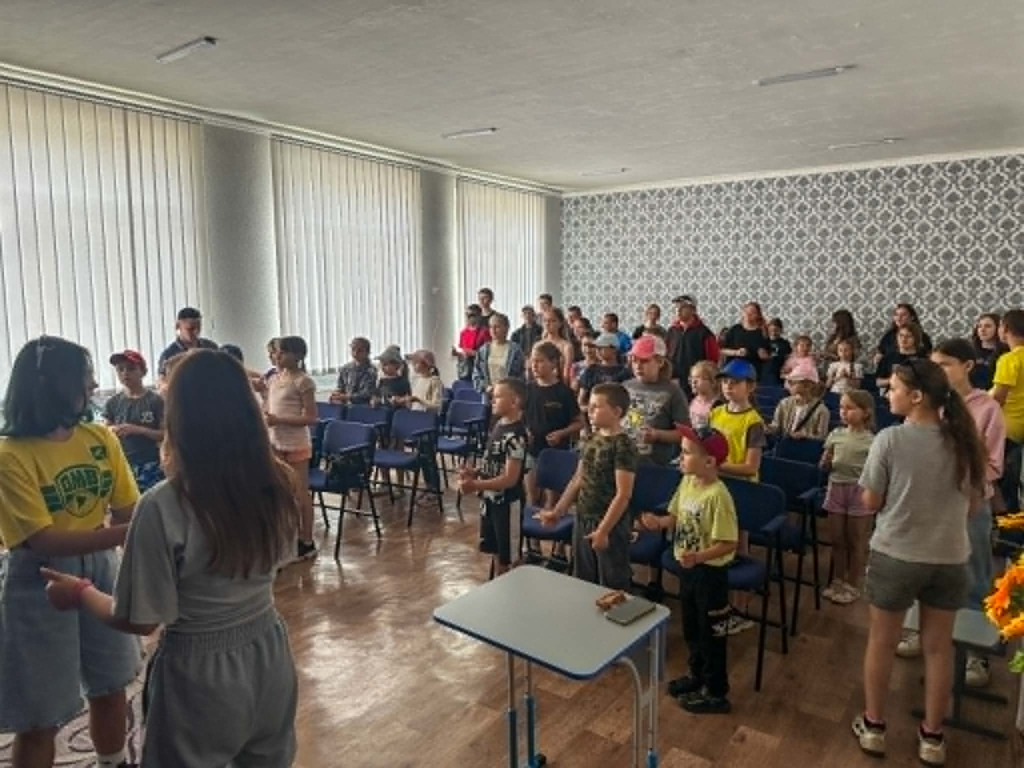 Children and young people gather for songs and activities during a summer camp session in Grintsevo.
