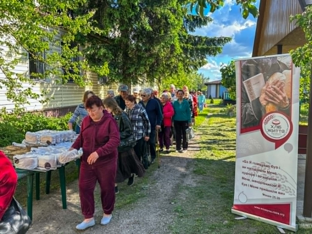 Local residents queue outside to receive freshly baked bread through the church outreach programme.
