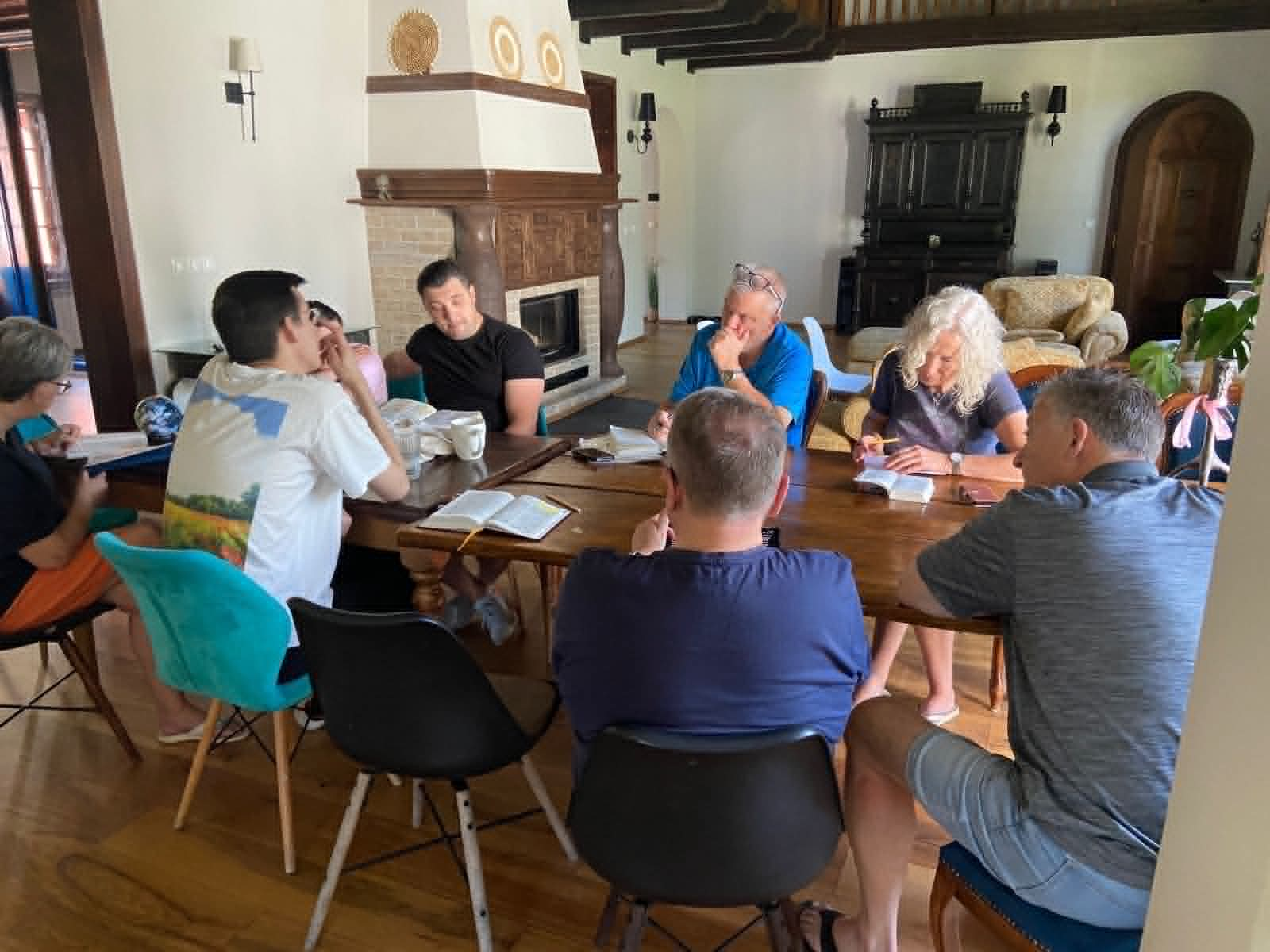 The team meeting with Bohdan sat around a dining table in a house.
