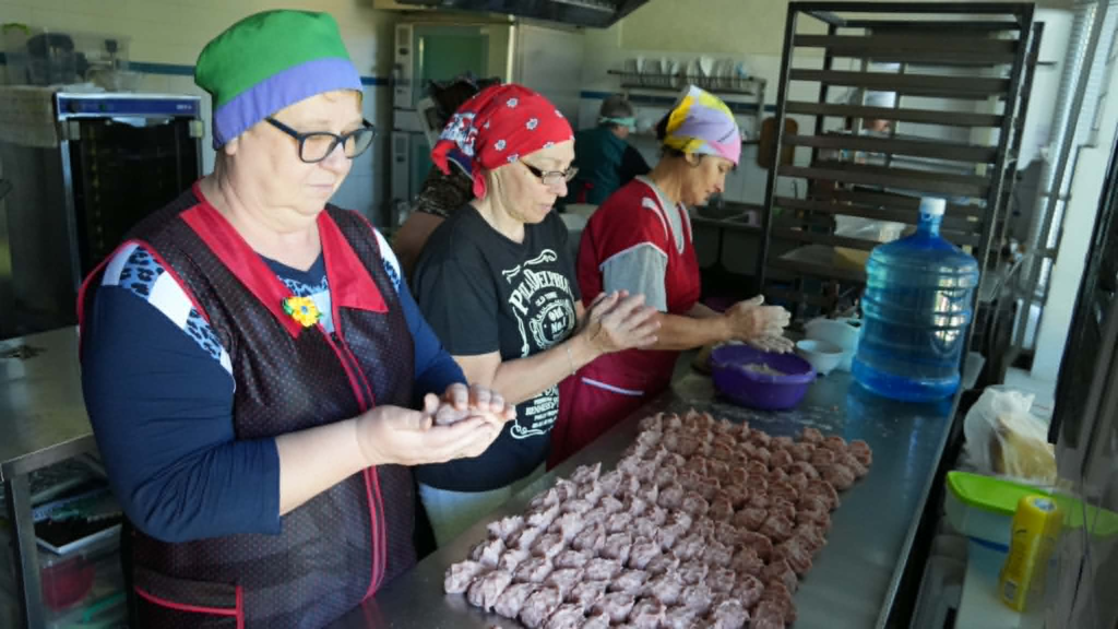 Volunteers prepare handmade dumplings in the kitchen, providing fresh meals for children attending the summer camp at the Centre.