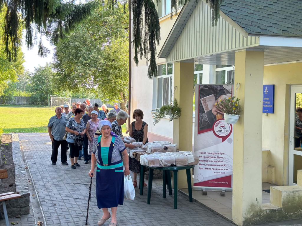 Local residents collecting freshly baked bread being distributed as part of the community support work in Lebedyn.