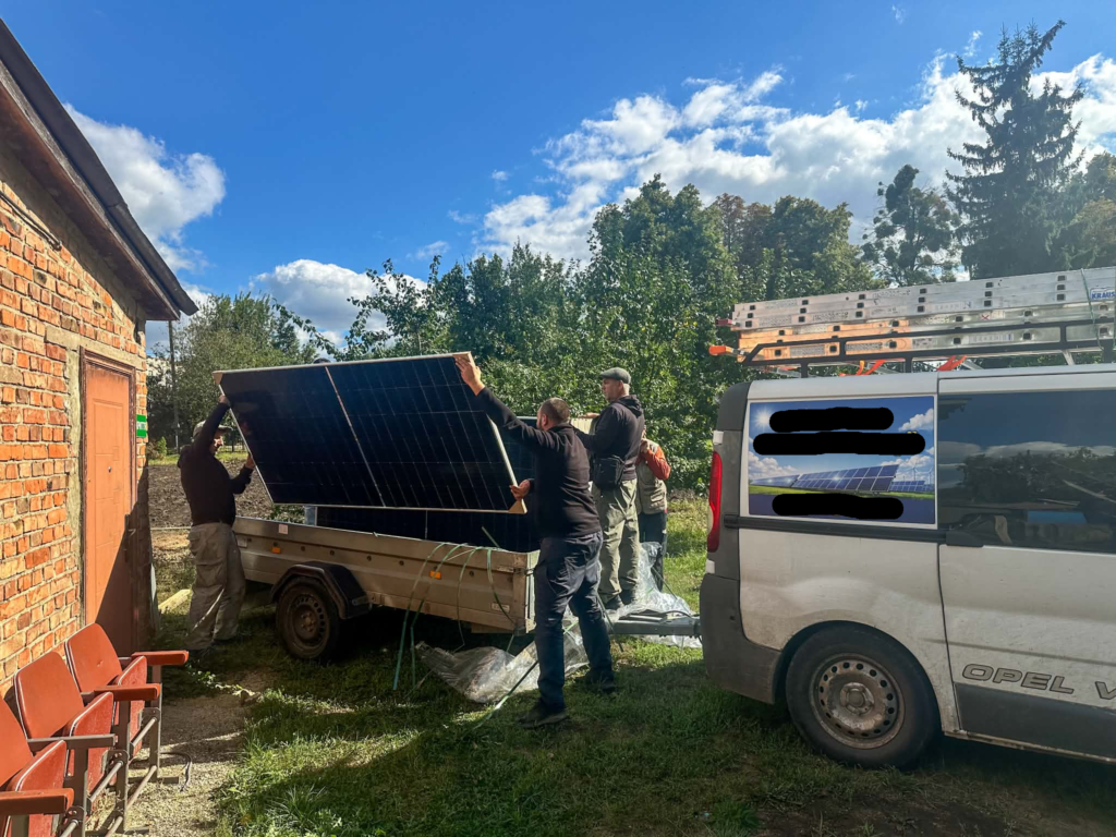 Workers moving solar panels into place during installation of the Centre’s new solar power system.