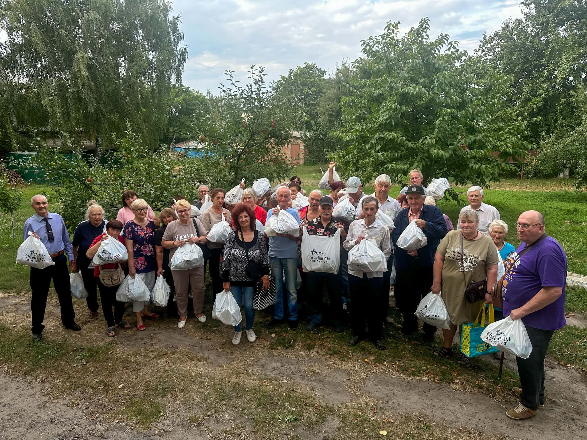 Refugees and local residents in the Lebedyn holding emergency food bags provided by the Centre.