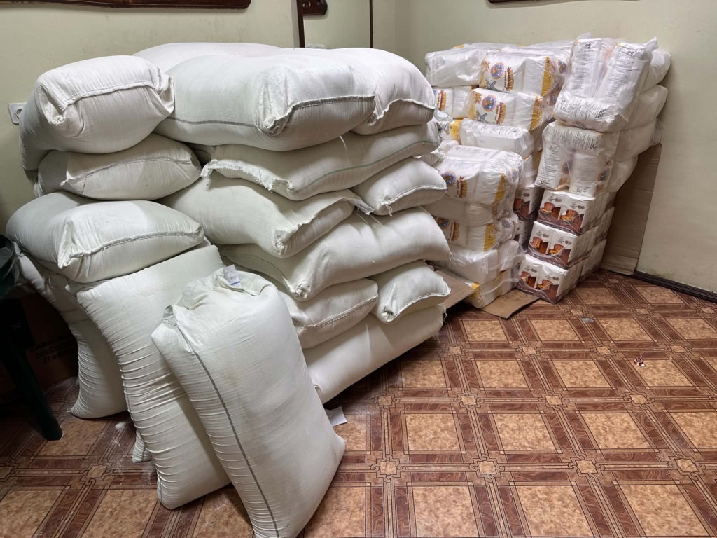 Large sacks of flour and packaged food supplies stacked indoors, ready for distribution to people in need in Lebedyn.